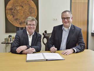 Professor Heinrich Köster, Präsident der TH Rosenheim, und Christian Pfeiffer, Deutsche Messe Hannover, freuen sich auf die Zusammenarbeit.