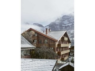 Moderner Holzbau in Elementbauweise, errichtet von der ARGE Holzbau Adelboden. Das Kreuzfirstdach ist mit Schiefer gedeckt, die Spenglerarbeiten sind in Kupfer ausgeführt.
